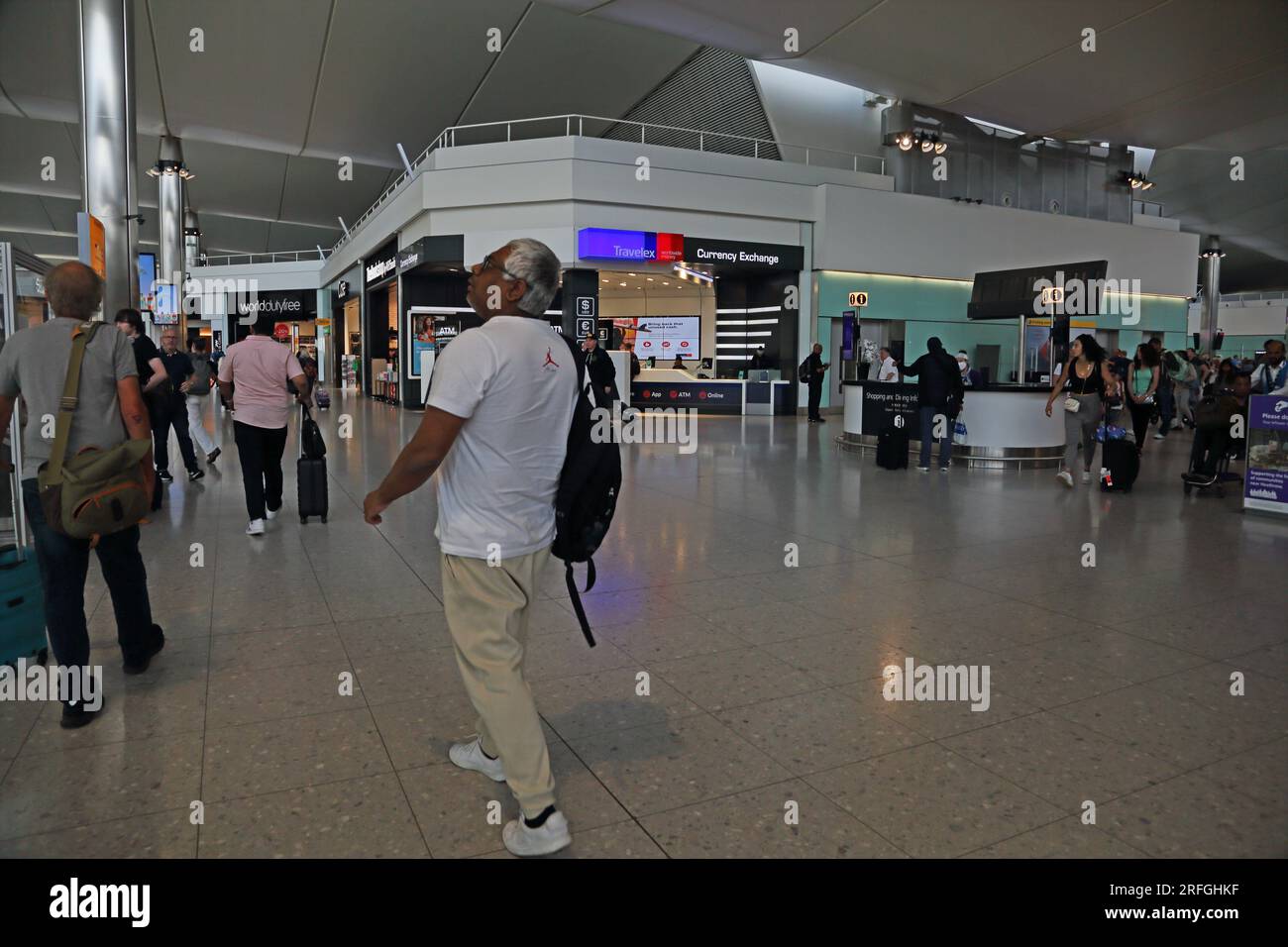 London Heathrow Airport England People in Terminal Two Departure Lounge, Duty Free Shops and Currency Exchange Stock Photo