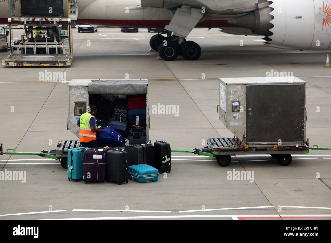 London Heathrow Airport England Baggage Handler Loading/Unloading Luggage Stock Photo