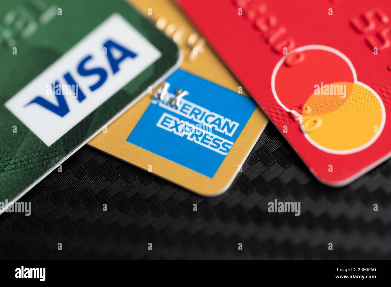 New York, USA - August 2, 2023: Visa master and american express debit cards on black table clsoe up view Stock Photo