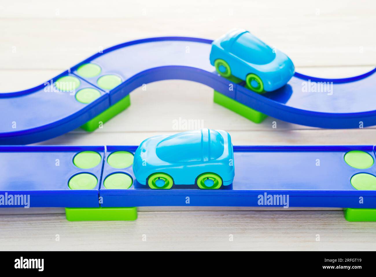 Toy cars and racing track on white wooden background Stock Photo