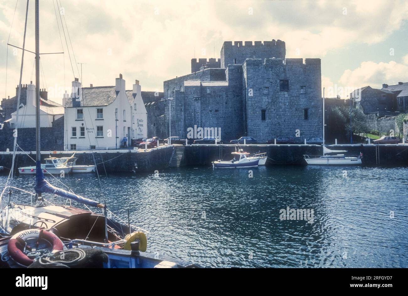 1989 archive photograph of Castle Rushen and the Castle Arms seen across the harbour at Castletown on the Isle of Man. Stock Photo