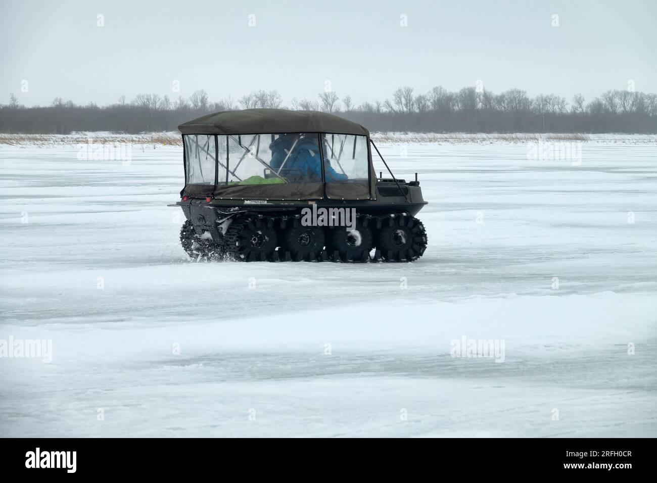 Russia, Svir river mouth- February 24, 2019: Snowmobiles on the ice of the North Sea. Use of oversnow vehicle by travelers and fishermen. Snowcar Stock Photo
