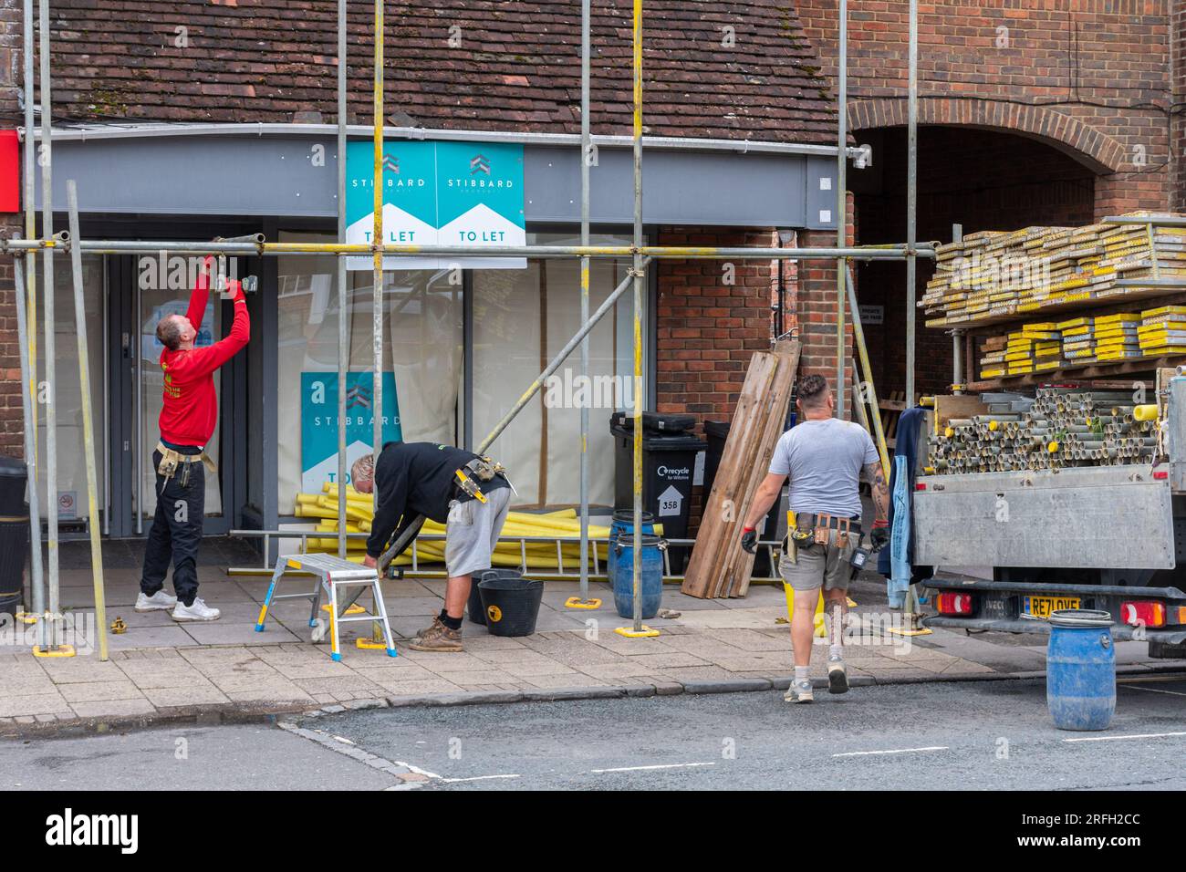 Scaffolders at work, setting up scaffolding around a building, England, UK. Job, jobs, occupation, occupations, trade, working Stock Photo