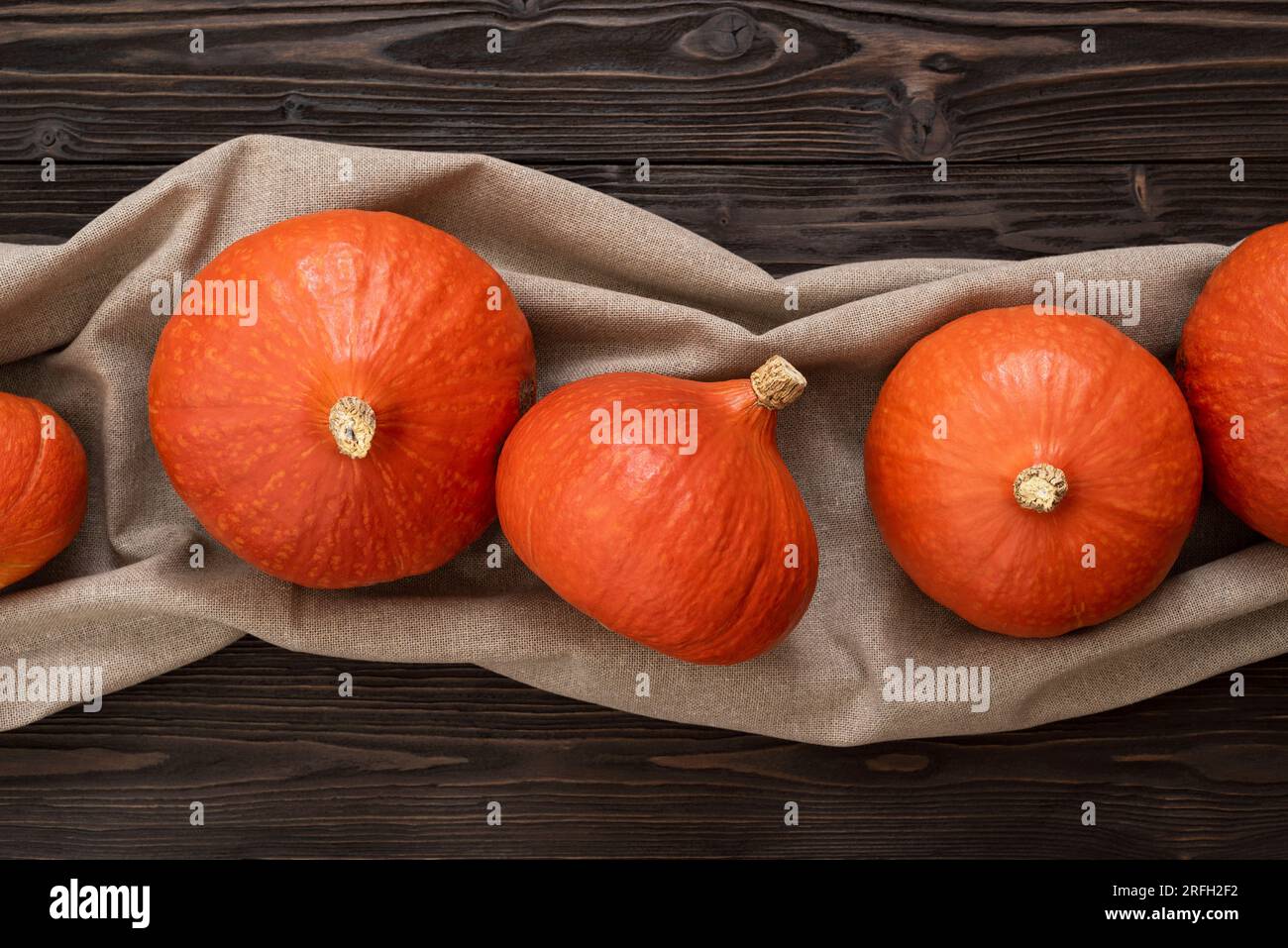 Harvest of Hokkaido Pumpkins or Red Kuri Squash on a Vintage Wooden Background Stock Photo