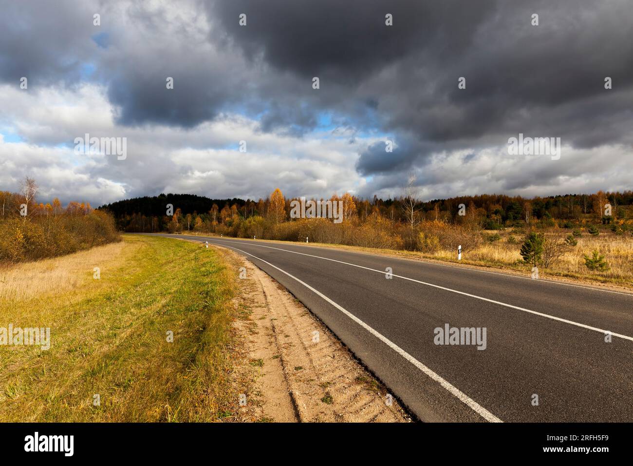 an asphalt road in the autumn season, an empty road among trees and ...