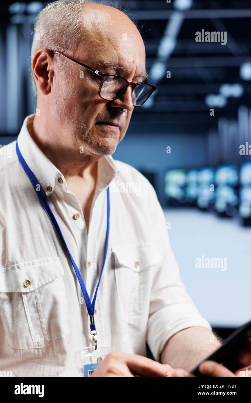 IT developer coding in server farm using javascript language. Proficient professional updating software on data center supercomputers on laptop terminal, ensuring optimal performance and security Stock Photo
