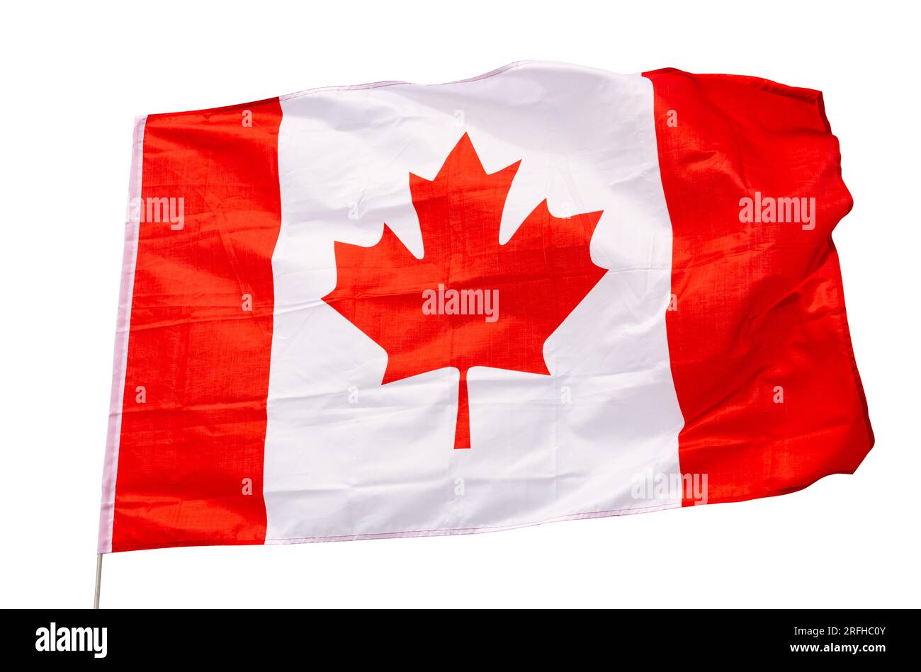 Canvas of Canadian flag flutters on flagpole against gray sky Stock Photo