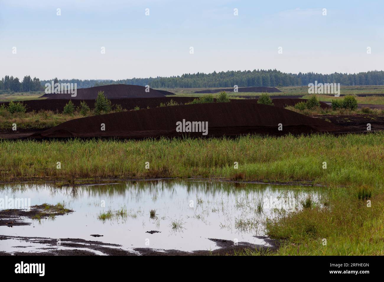 black peat is stacked in huge piles for loading on transport, the ...