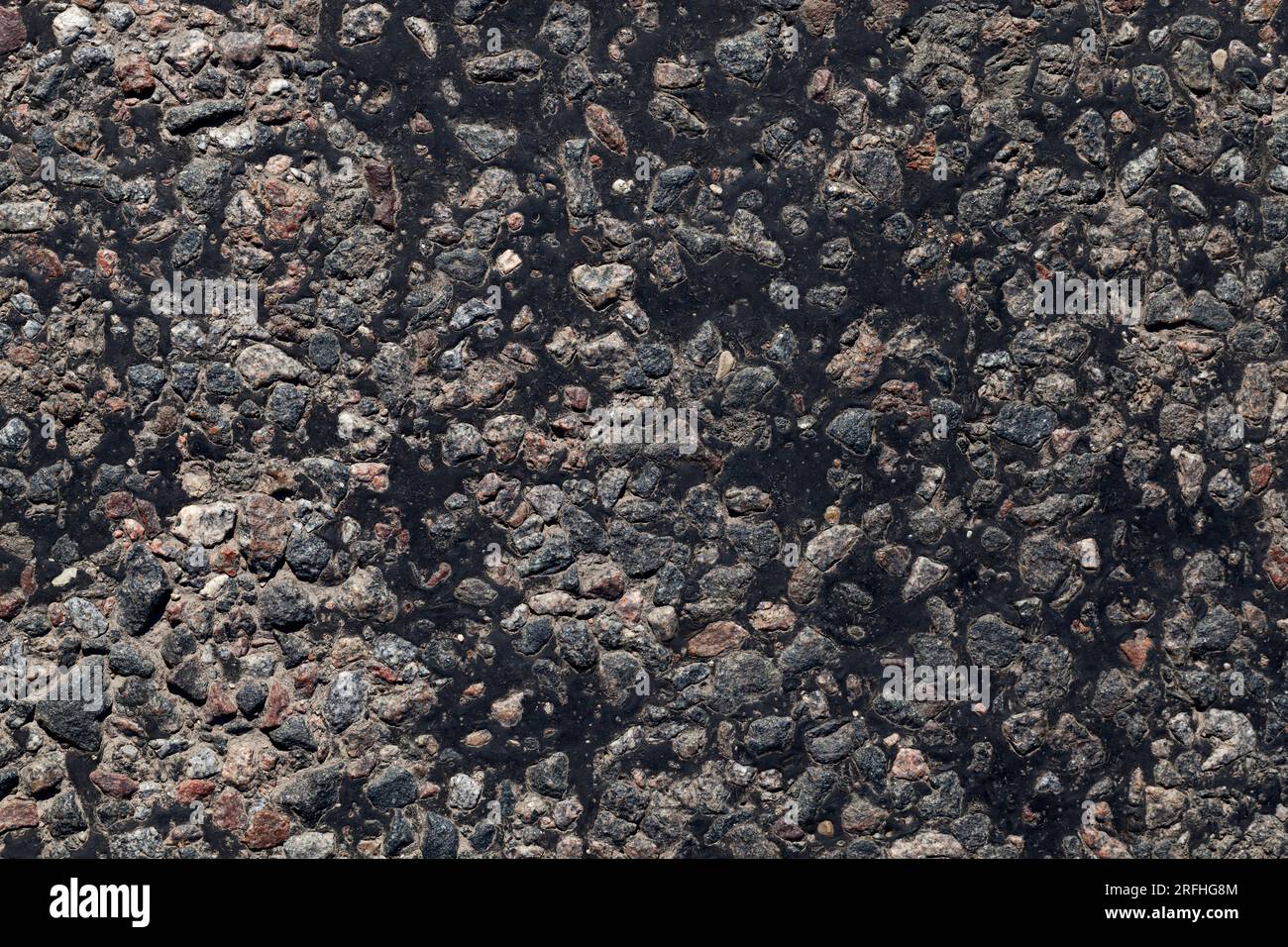 paved road, a close up of a part of the carriageway of an asphalt road, a road made of crushed stone, resin and other building materials Stock Photo