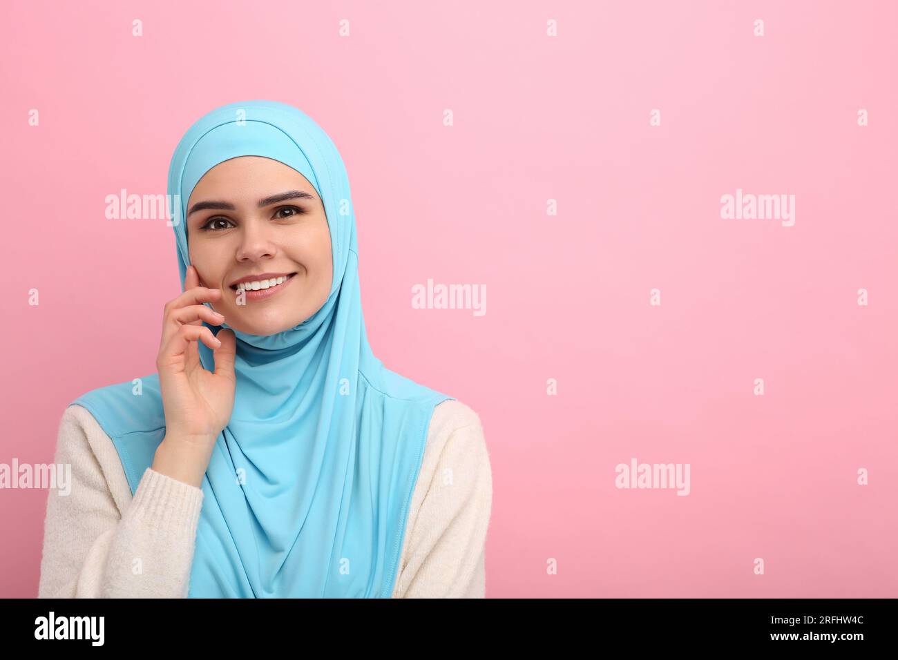 Portrait of Muslim woman in hijab on pink background, space for text ...