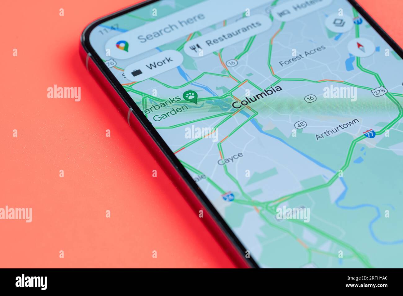 New York, USA - July 21, 2023: Car traffic on Columbia google maps on smartphone screen close up view with red background Stock Photo