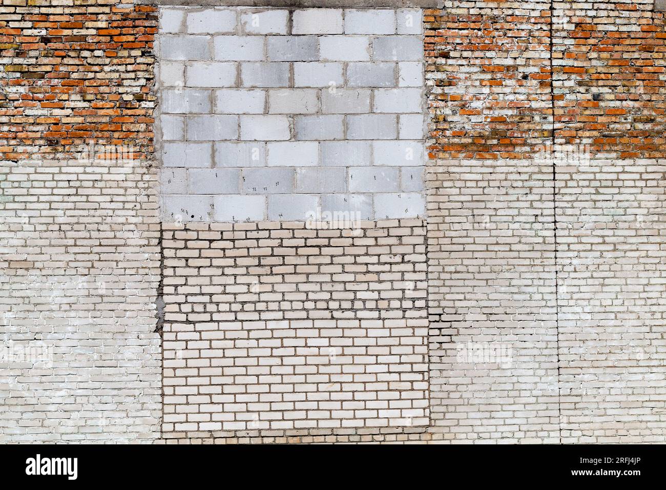 the wall of the building is made of different quality and types of bricks and blocks, mixed