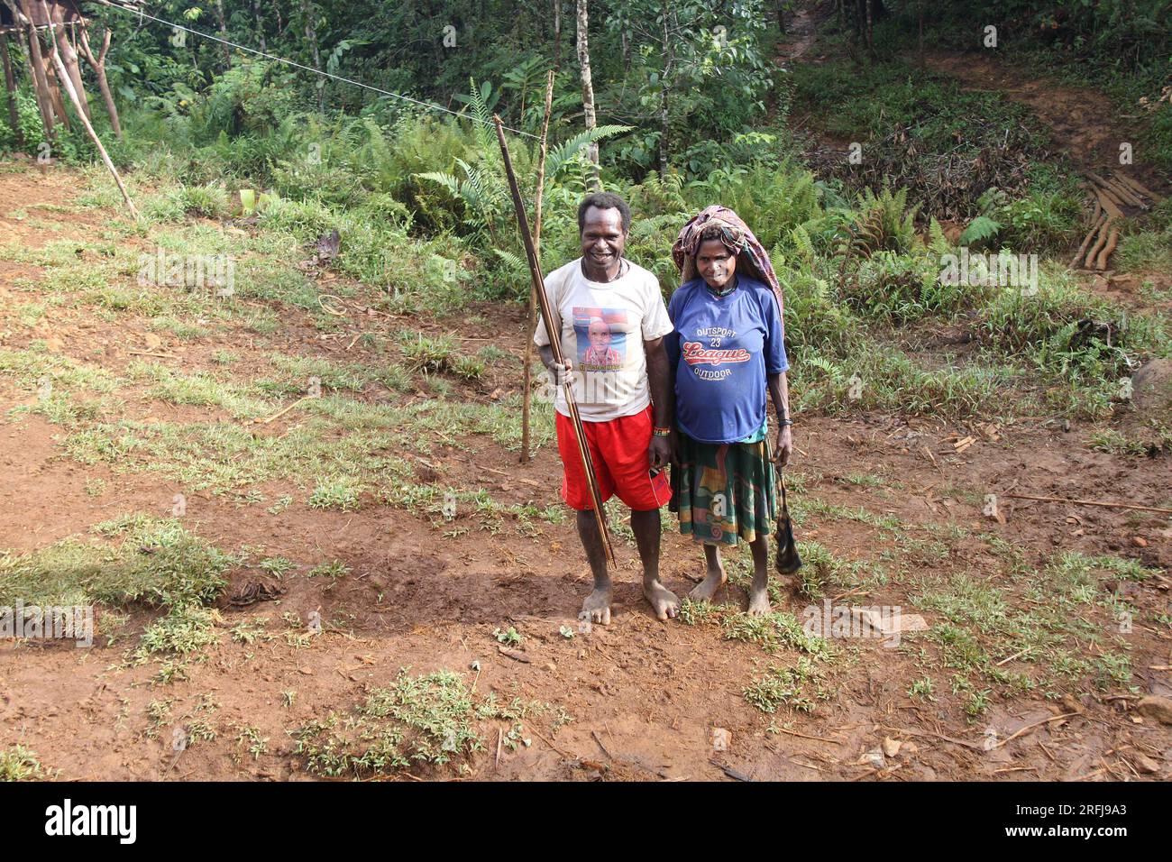 Two Papuan people, a man and a woman, stand facing the camera. in the Papuan highlands in Papua, Indonesia. Stock Photo