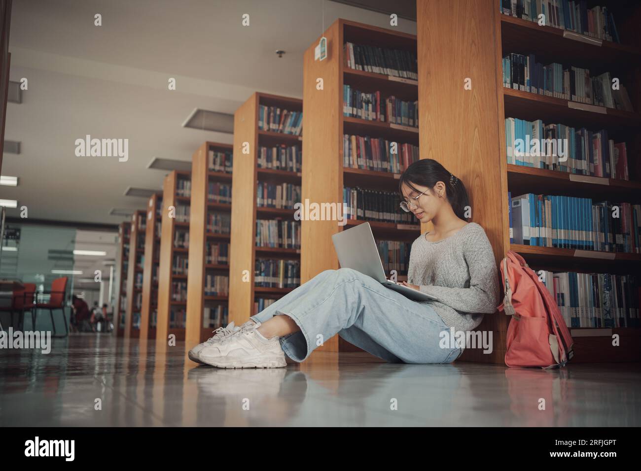 Student girl sitting on floor and using laptop, Writes notes for paper ...