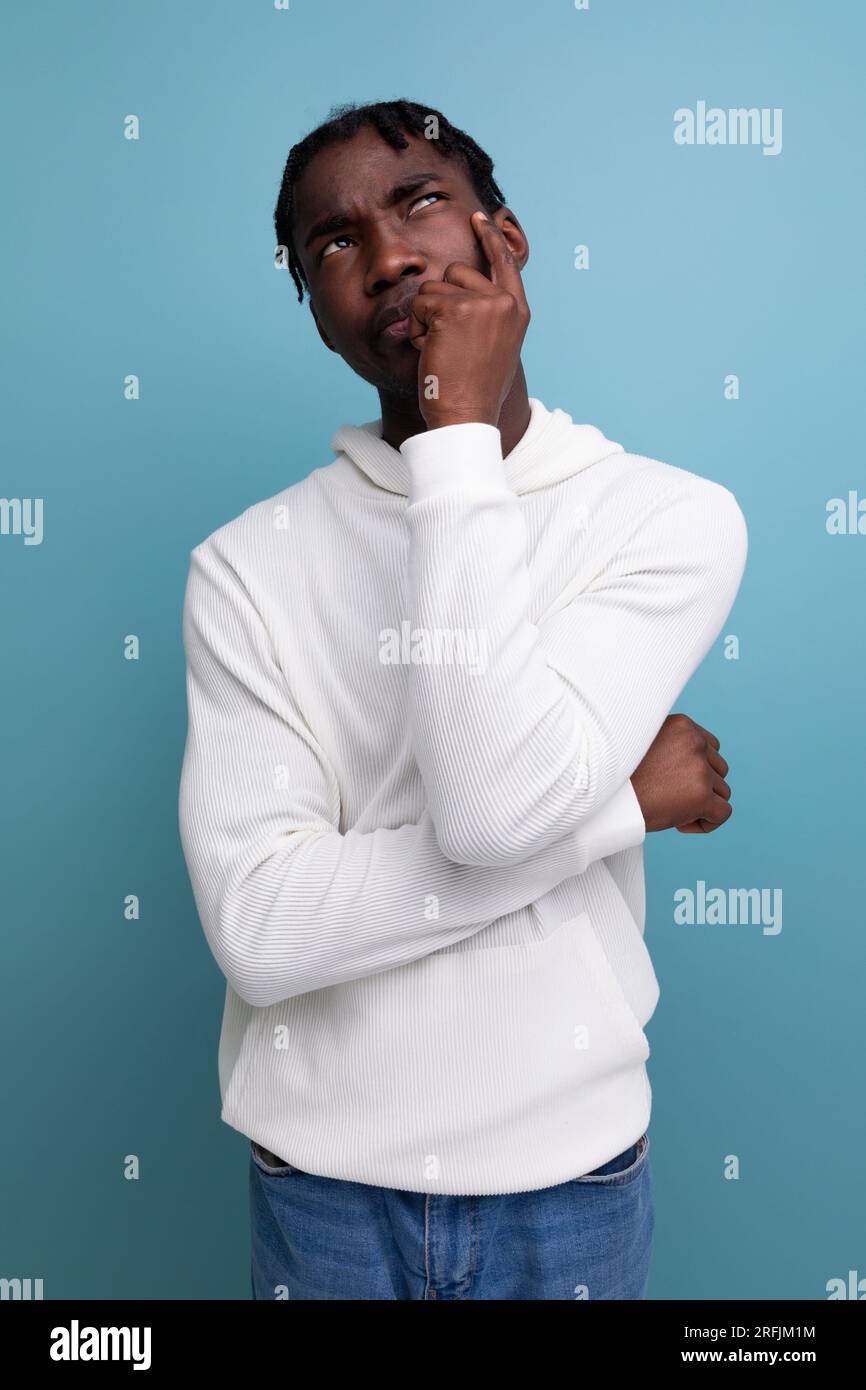smart dark-skinned young brunette man solves a problem in his head Stock Photo