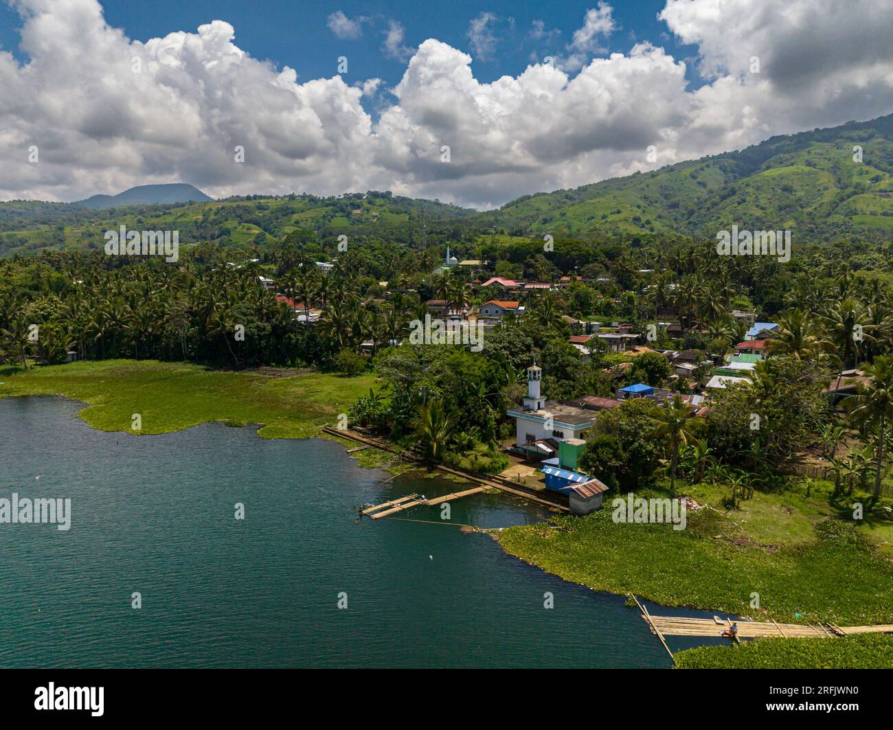 Butig Lake Lanao and small town in lake coast. Mountain green forest. Blue ...