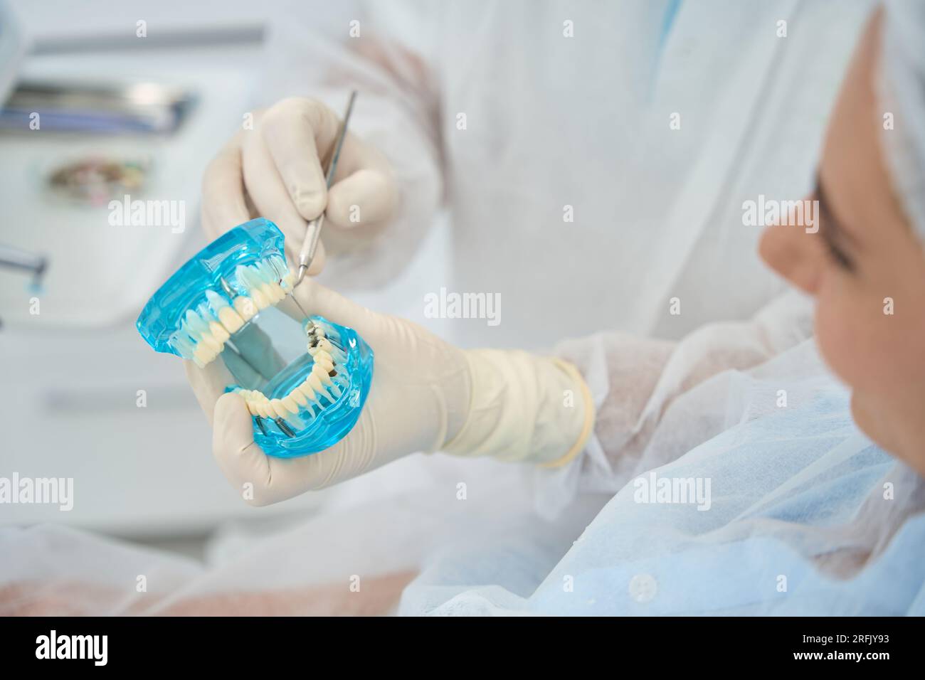 Doctor orthodontist shows patient model with dental implants and ...