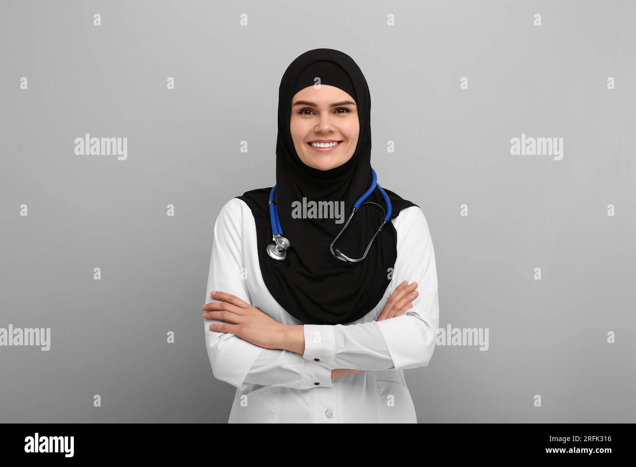 Muslim woman wearing hijab, medical uniform with stethoscope on light