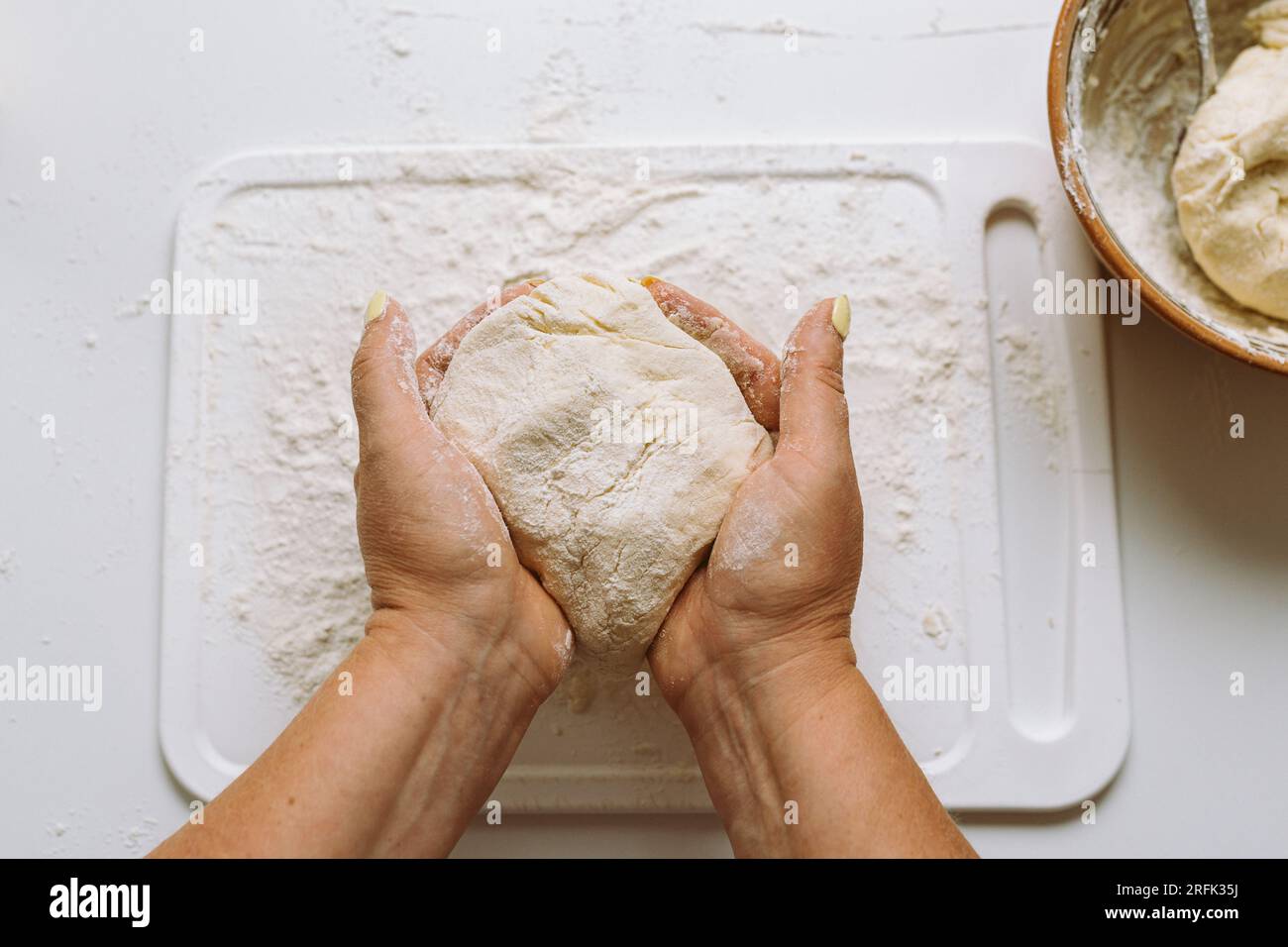 Female hands knead dough Stock Photo