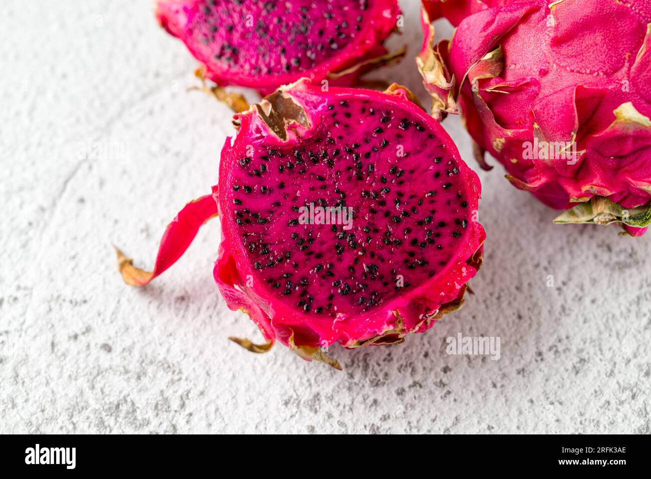 Ripe red dragon fruit on stone table Stock Photo