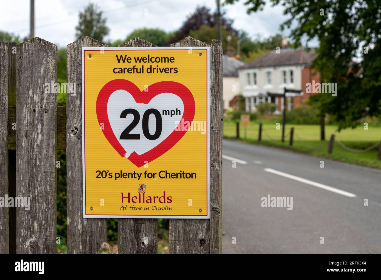 Bright yellow sign informing drivers that 20 mph is enough through rural villages. August 2023 Stock Photo