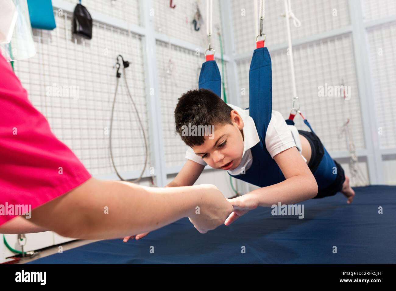 physical therapy room, physically disabled child exercising with