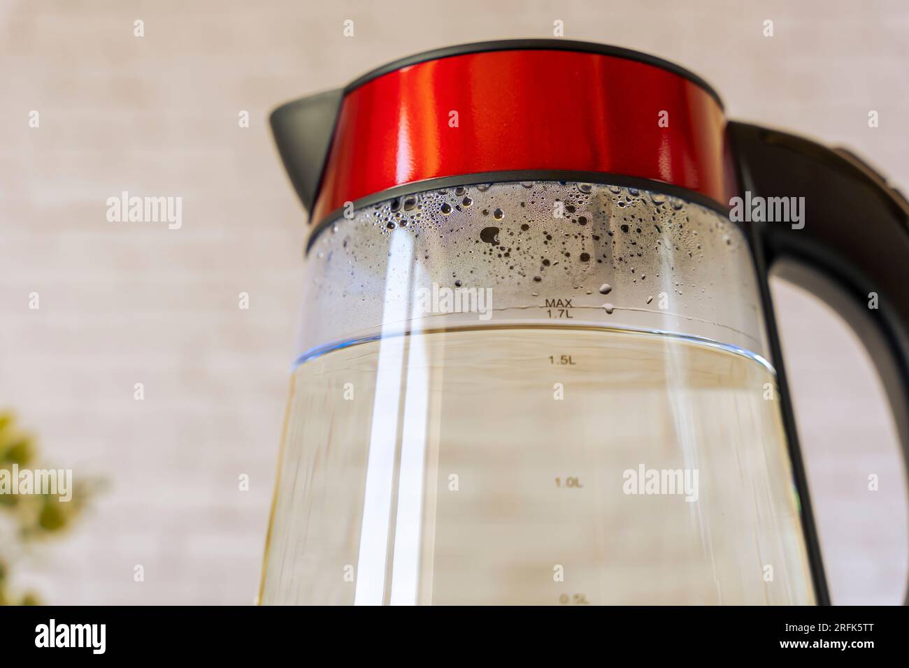 electric kettle with boiling water and condensate on glass walls
