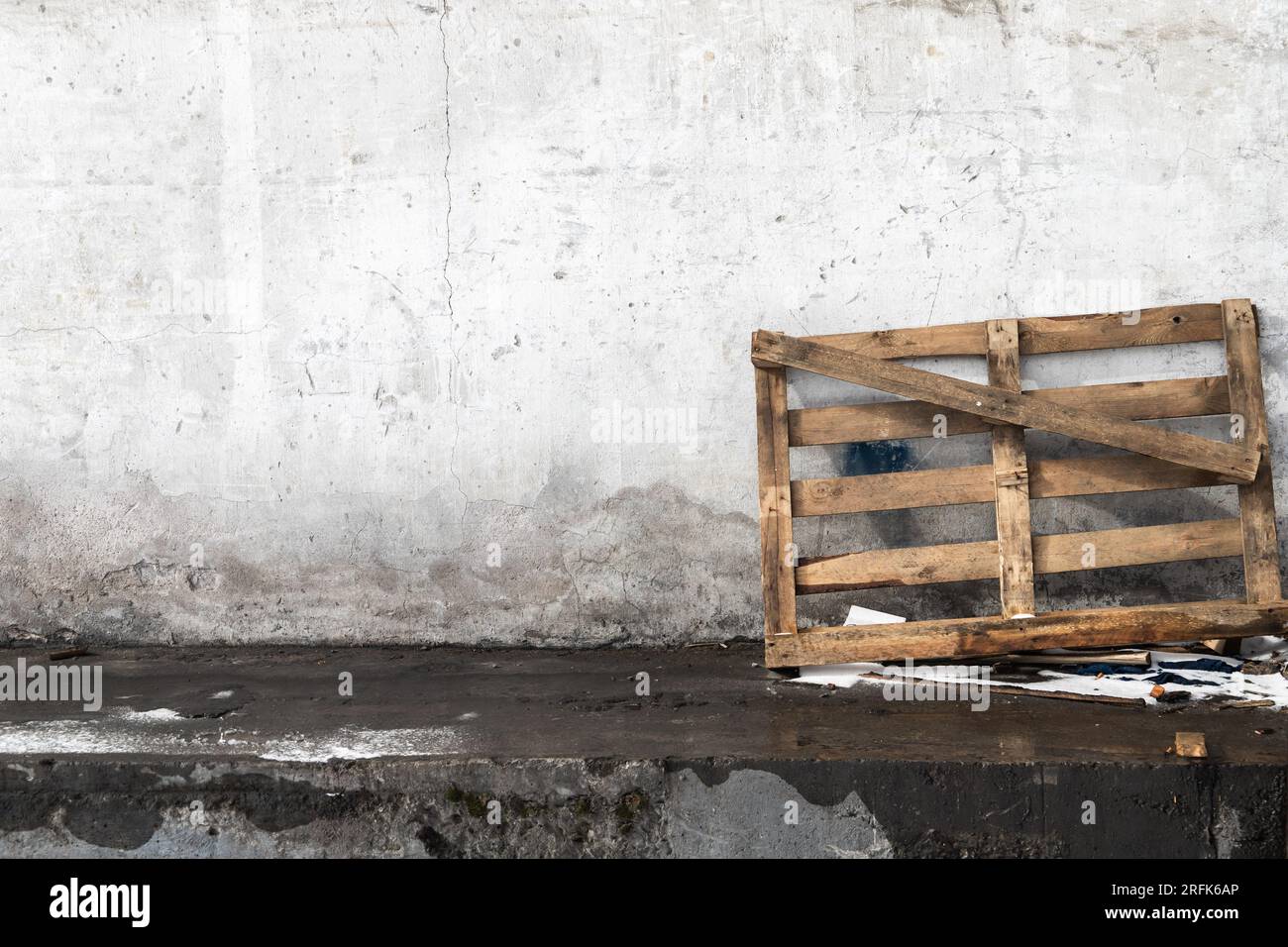 A wooden pallet stands leaned against the wall in the loading area Stock Photo
