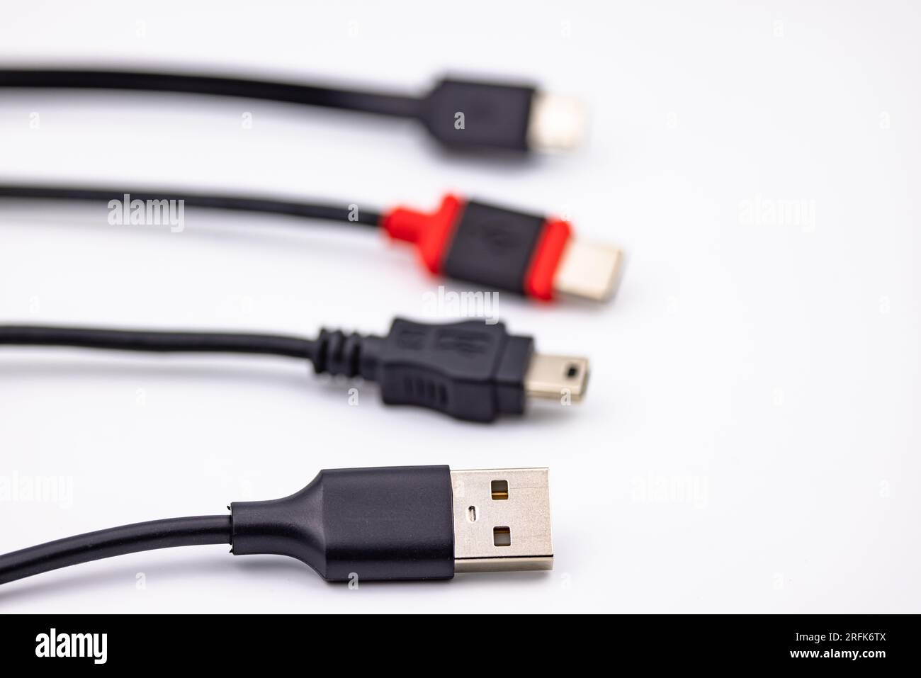 Mini USB connector and cable alongside other USB type adapters isolated in studio against white background Stock Photo