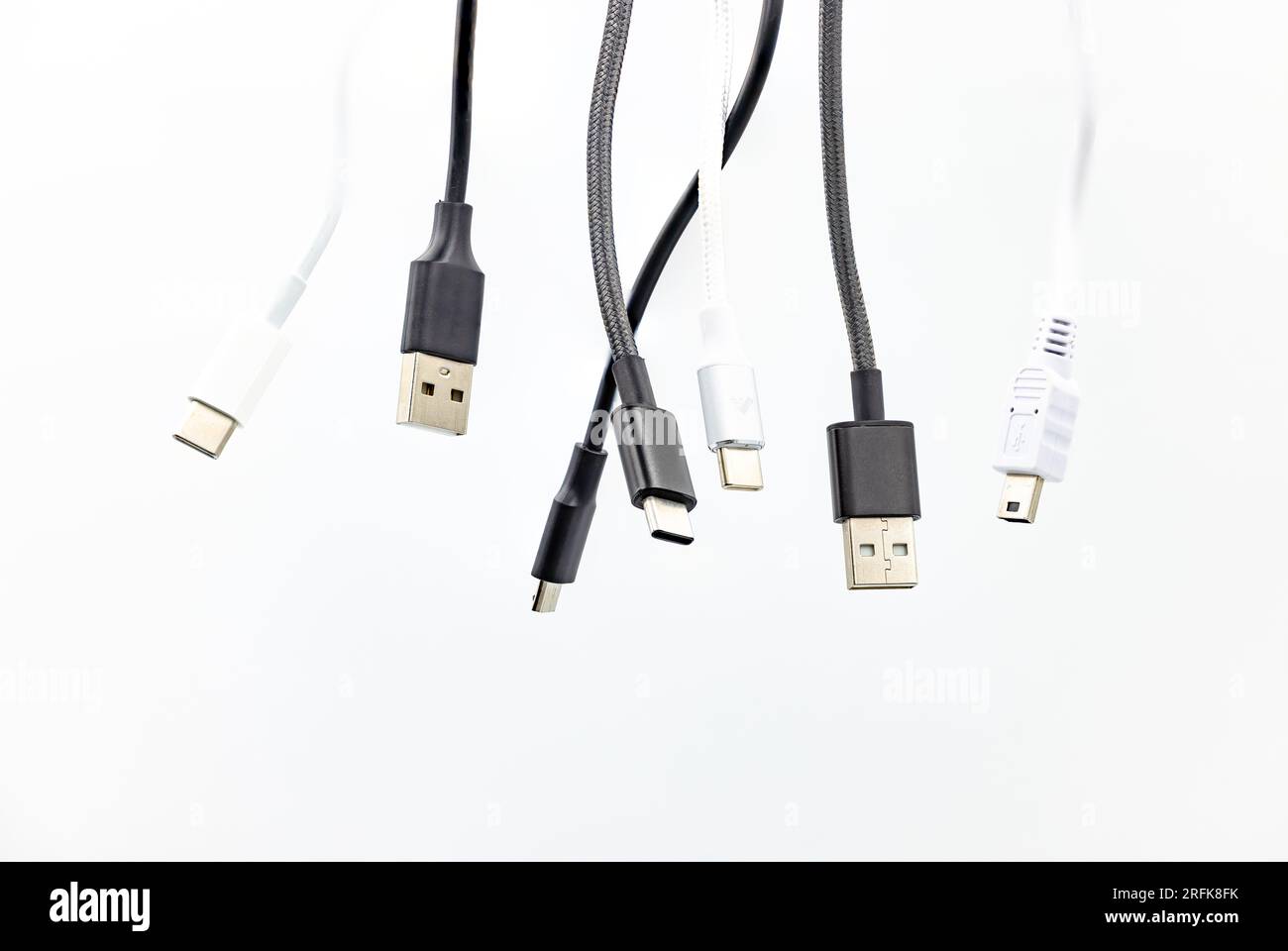 Chaos with different USB type plugs and standards isolated in the studio against a white background Stock Photo