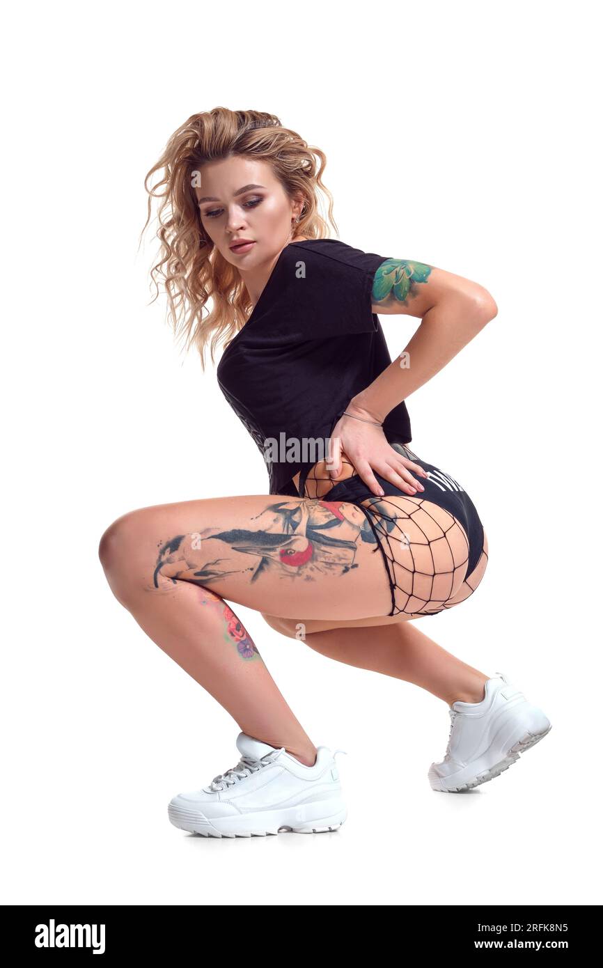 beautiful blonde girl in booty shorts and fishnet dancing twerk isolated on  white background Stock Photo - Alamy