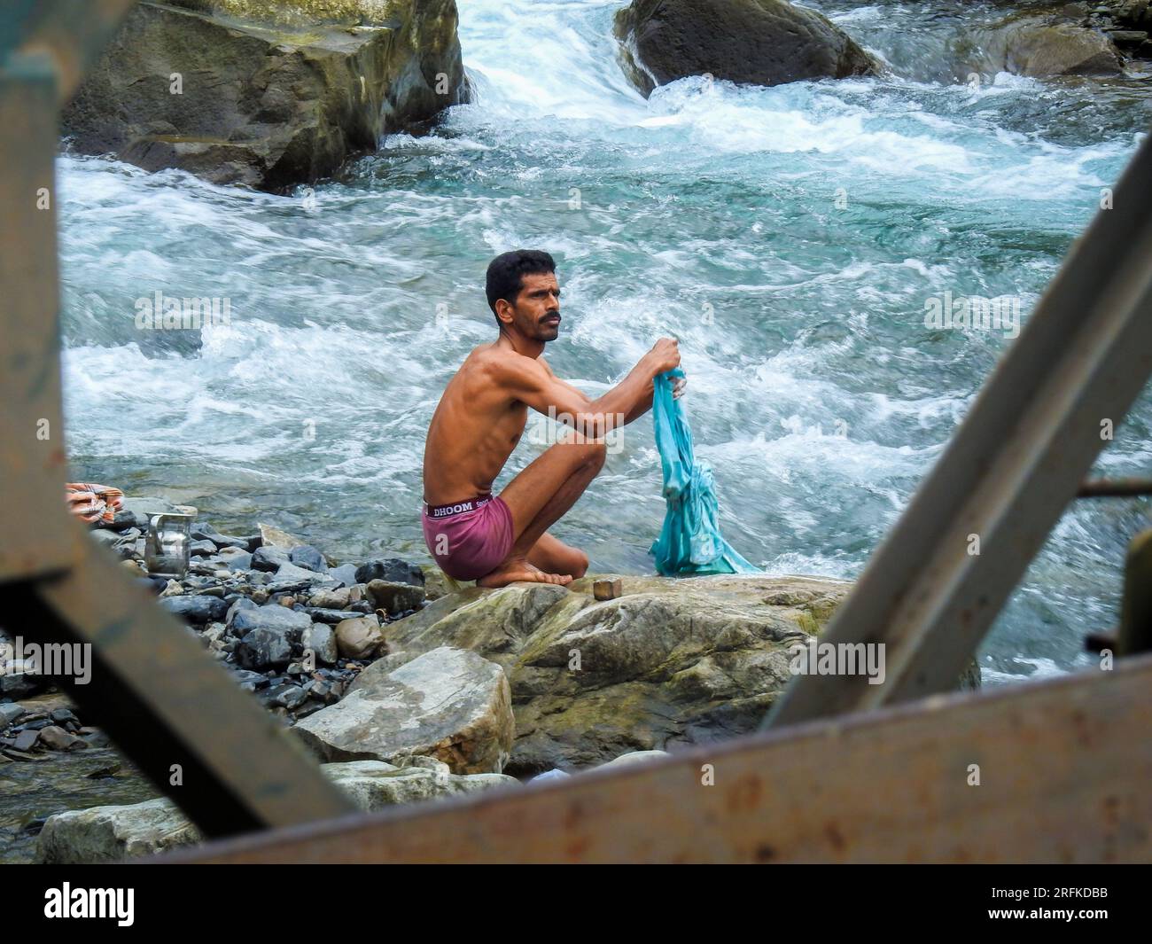 Oct.14th 2022 Uttarakhand, India. Local man washing clothes after a river bath in Dehradun City outskirts, Uttarakhand. Embracing traditional river-si Stock Photo