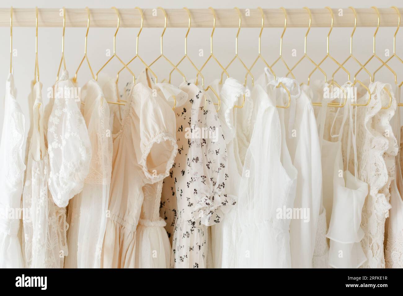 delicate rack of neutral dresses on gold hangers Stock Photo