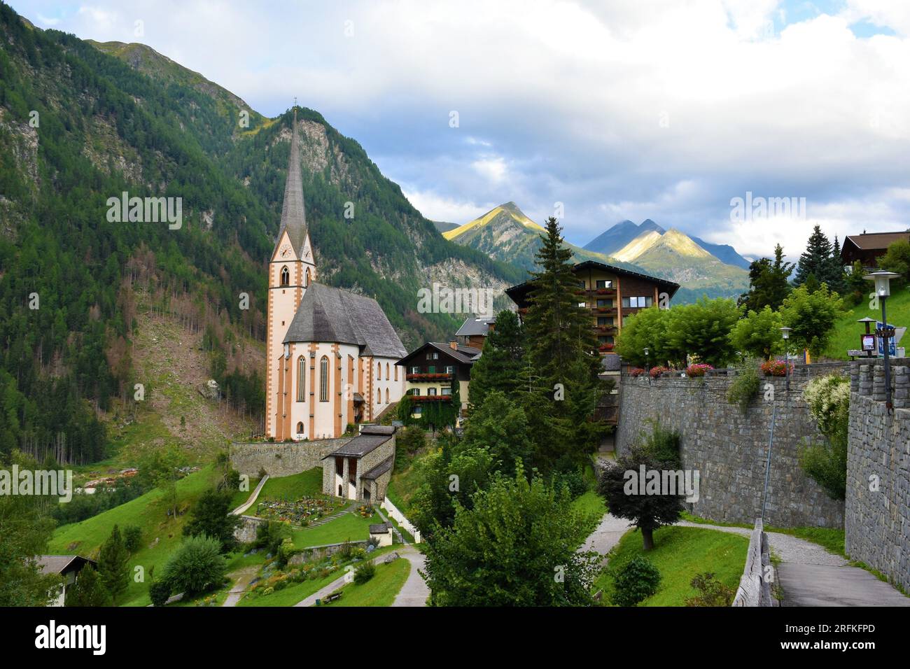 View of St Vincent Church in Heiligenblut am Großglockner in the district of Spittal an der Drau in Carinthia, Austria.with Grossglockner massif in Ho Stock Photo