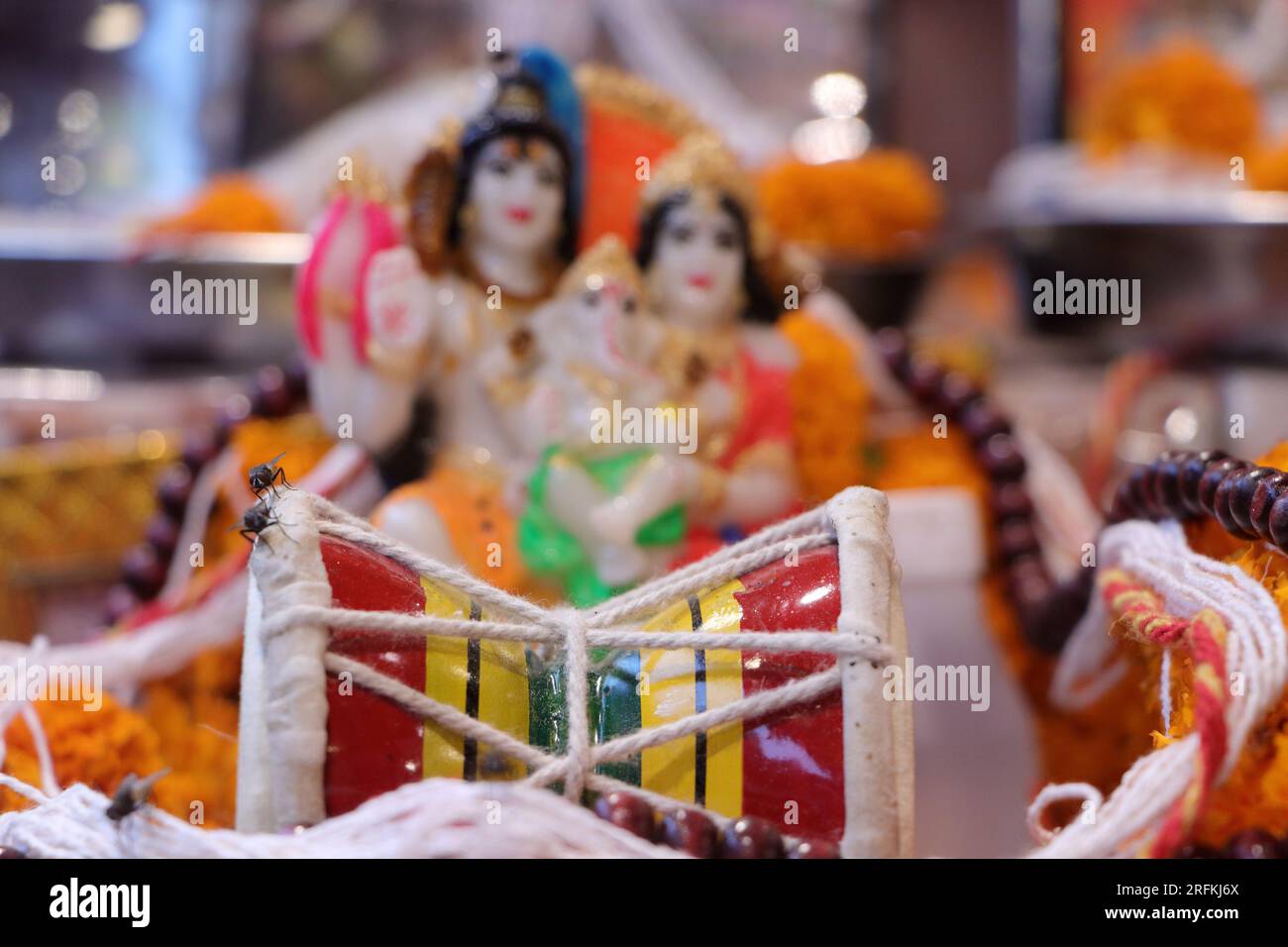 Damru, with the idol of Lord Shiva Parvati With different focus, Damru is a small musical instrument. Stock Photo