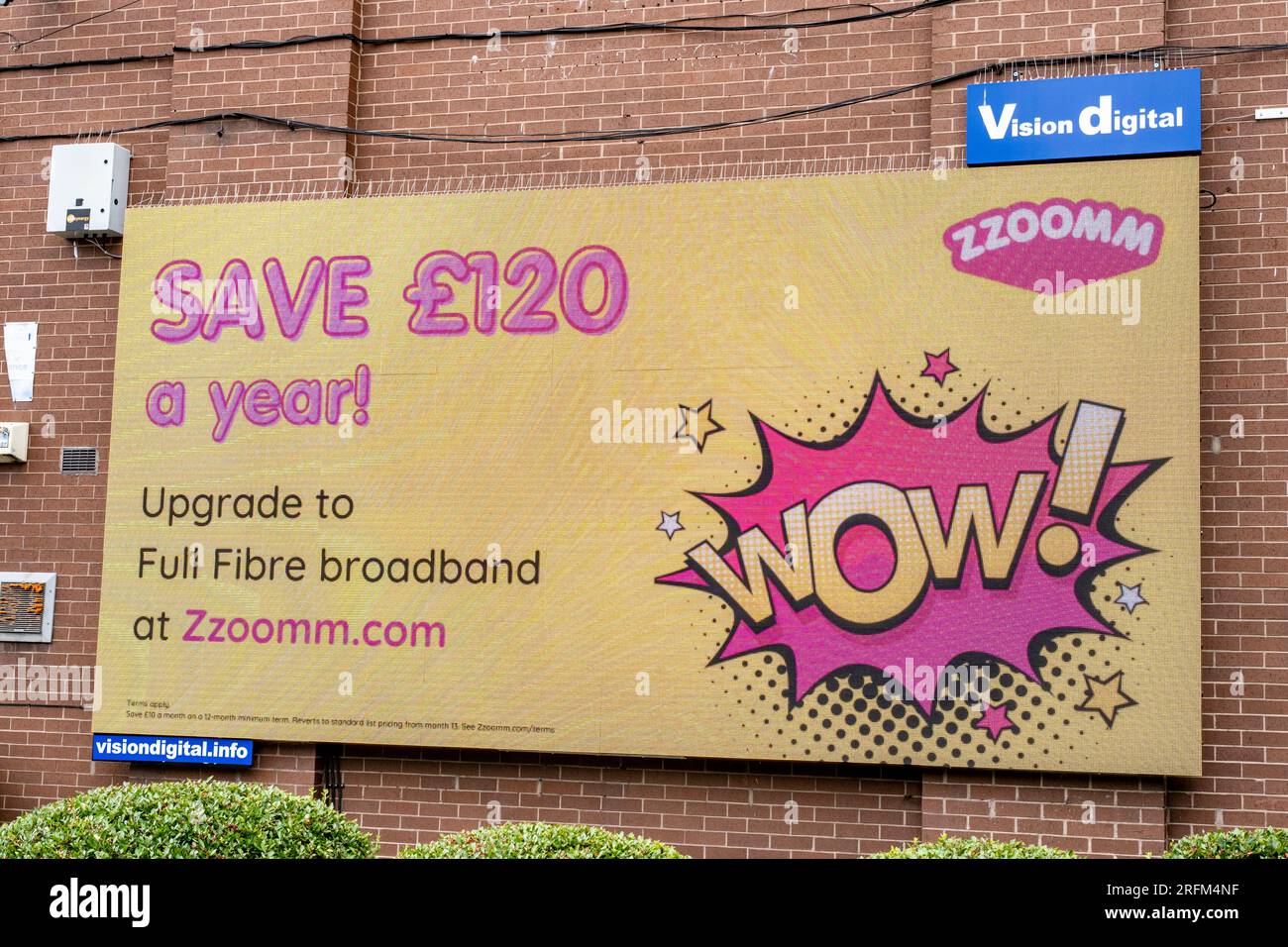 Zzoomm LED billboard promoting full fibre broadband on outside wall in Crewe Cheshire UK Stock Photo