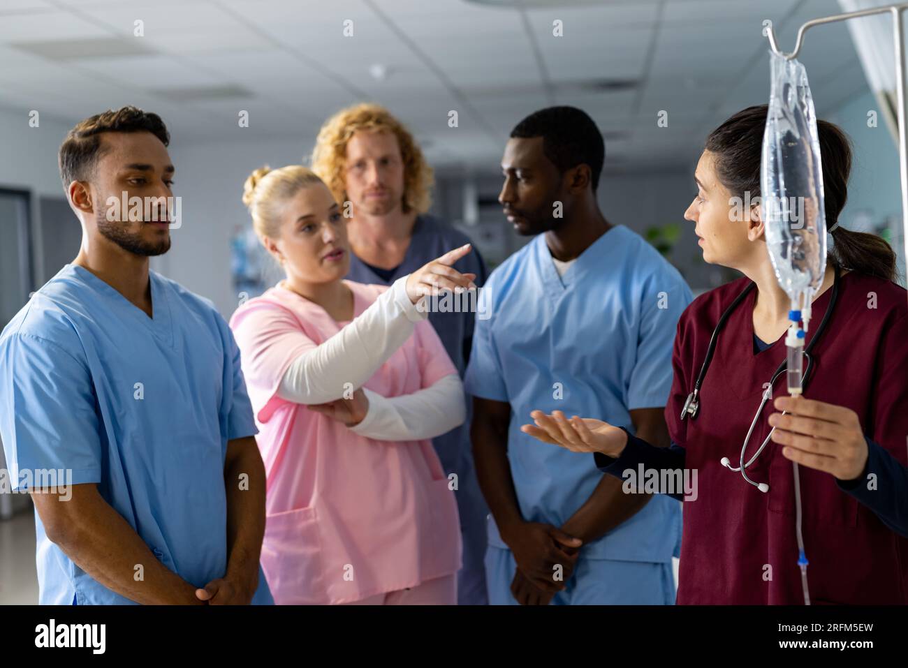 Caucasian female doctor with diverse trainee doctors applying drip at hospital Stock Photo