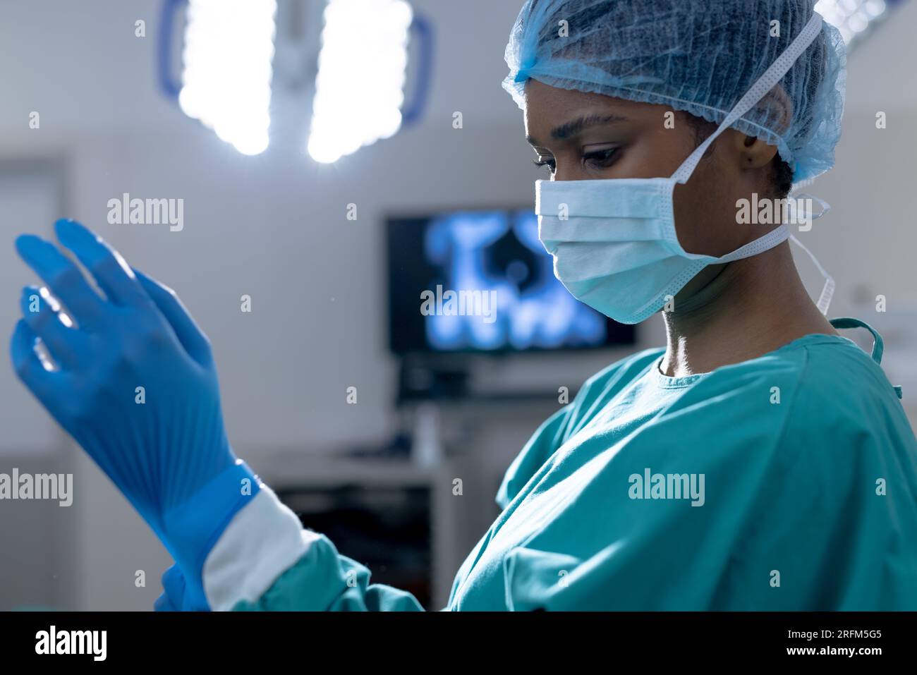 African american female surgeon wearing surgical gown and gloves in ...
