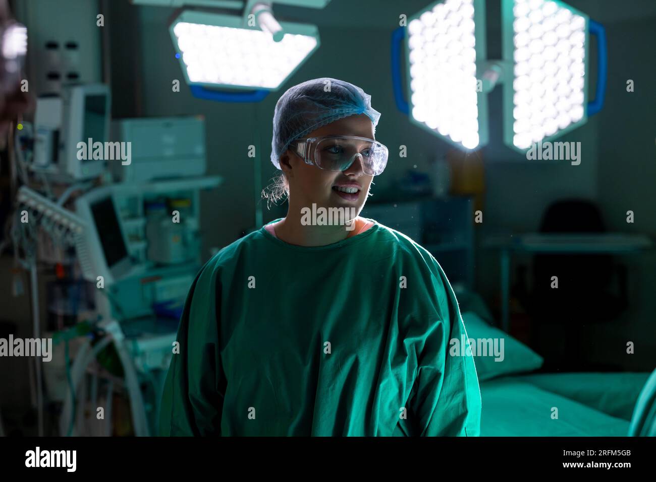 Caucasian female surgeon wearing surgical gown in operating theatre at hospital Stock Photo