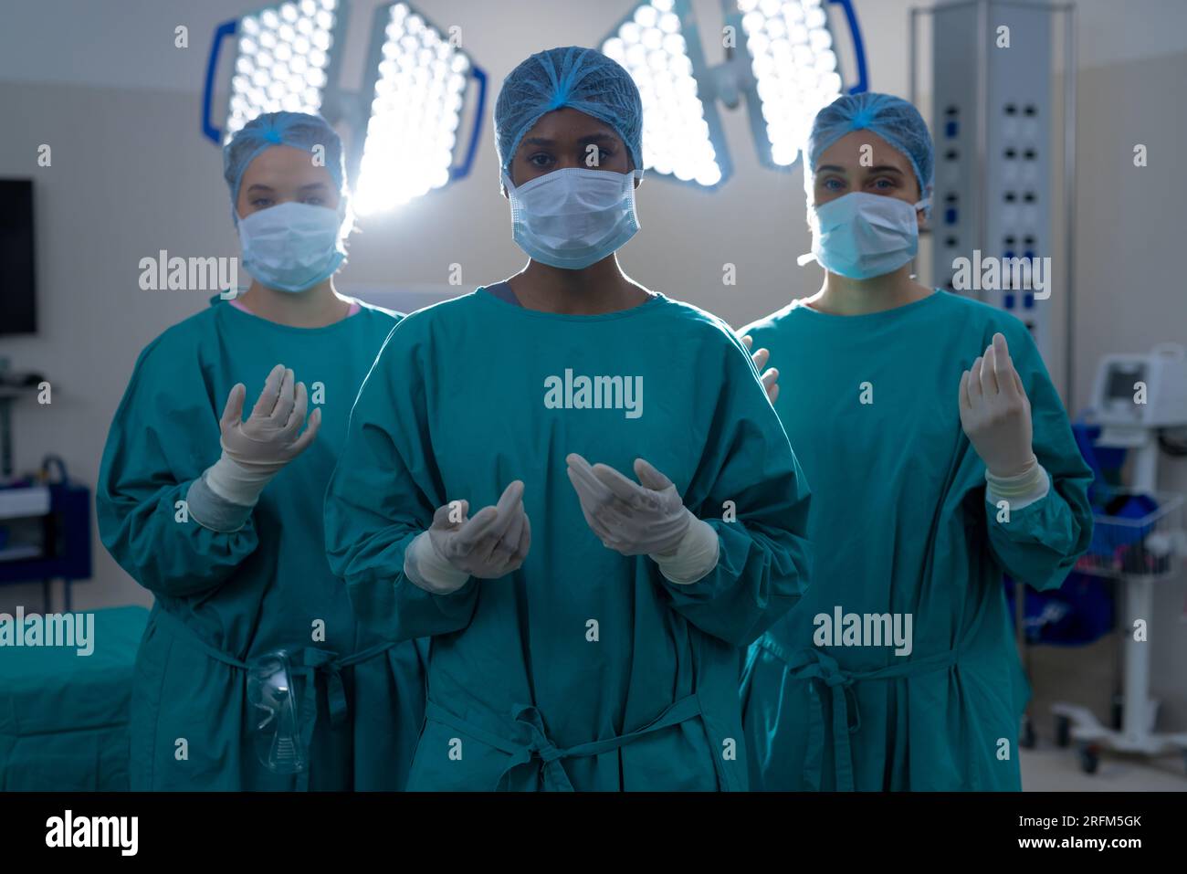 Portrait of diverse female surgeons wearing surgical gowns in operating
