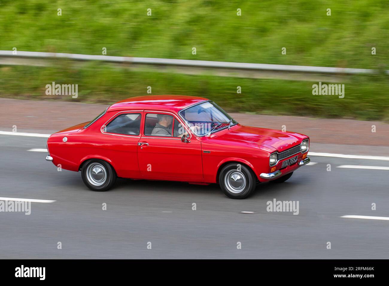 1970 70s seventies Red Ford Escort Lotus Petrol 1558 cc travelling at speed on the M6 motorway in Greater Manchester, UK Stock Photo