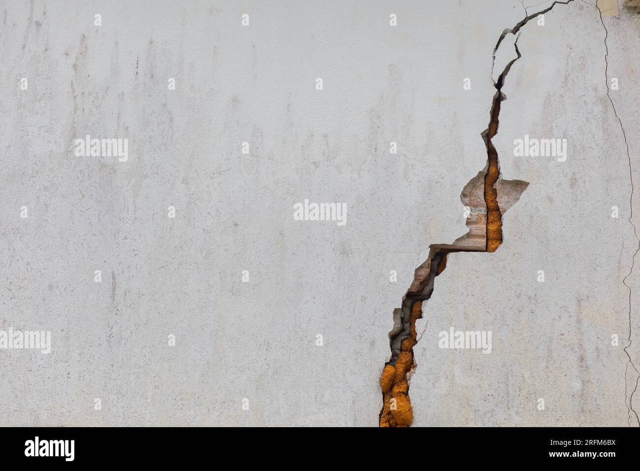 Cracked white cement walls indicate insecurity and repairs. Stock Photo