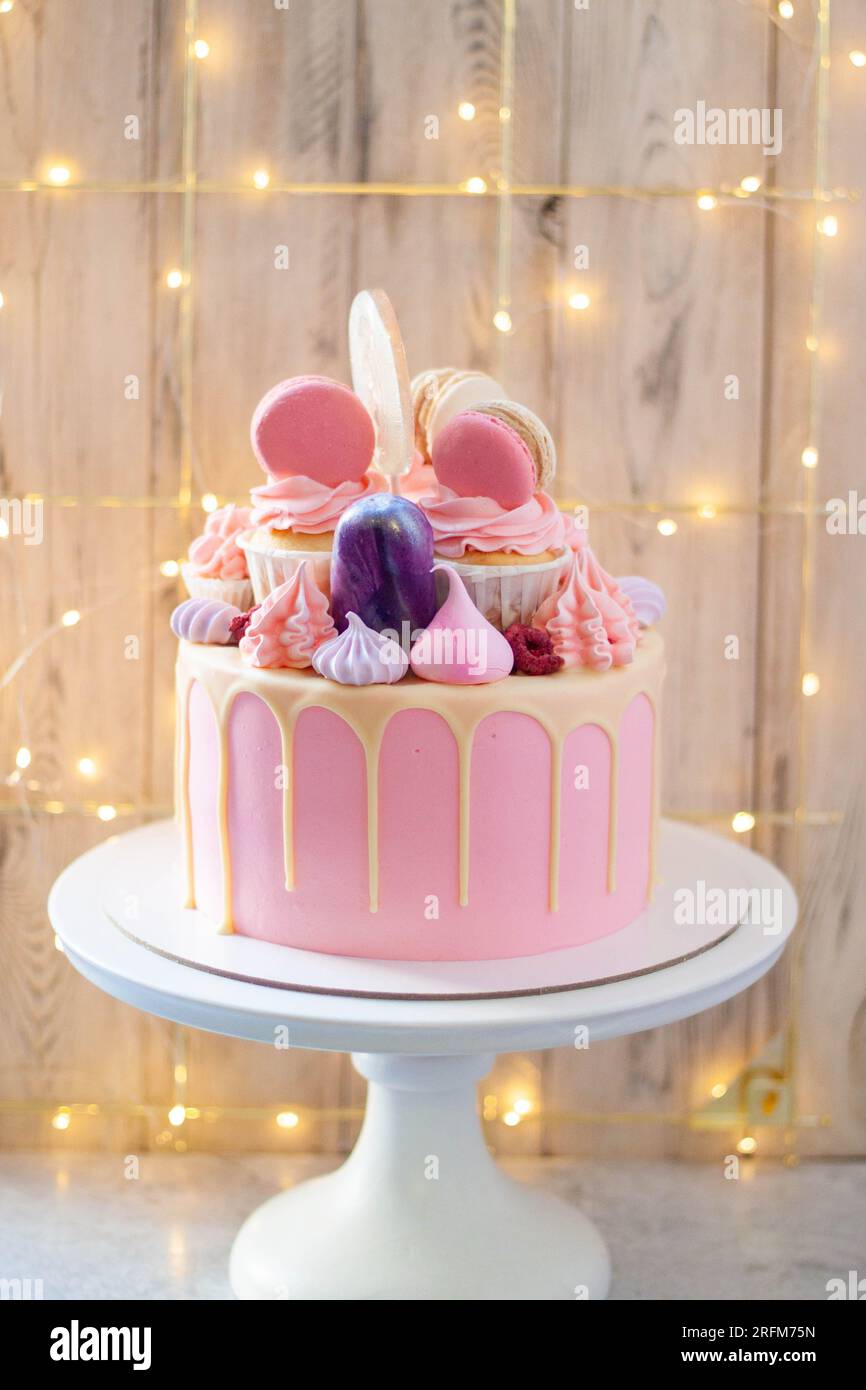 Tender and elegant pink cake decorated with melted white chocolate ...