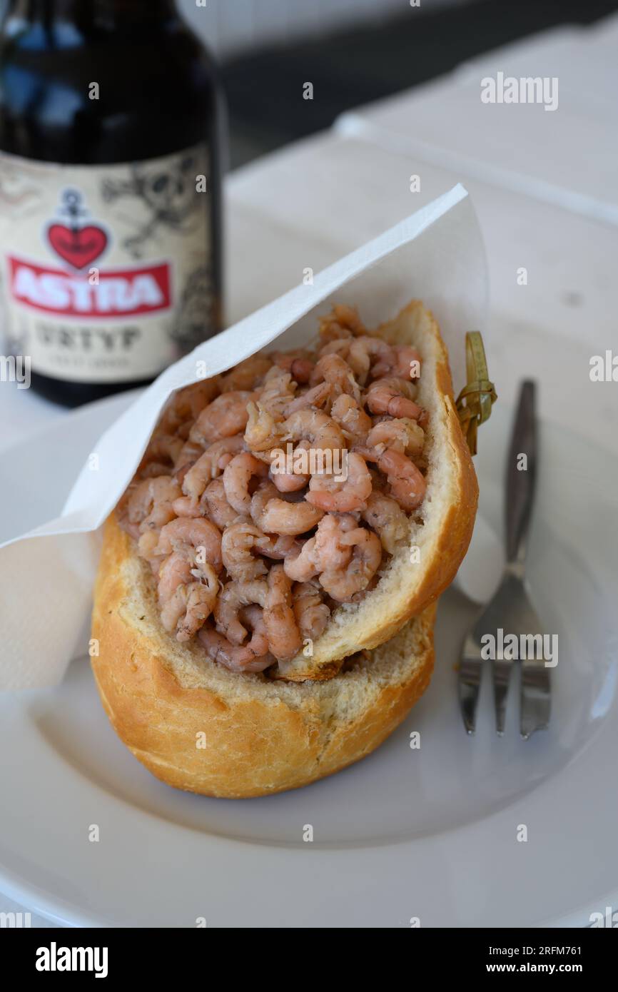 Hamburg, Germany - June 14 2023: North Sea Crab Sandwich or Nordseekrabben Brotchen with a Bottle of Astra Pilsner Beer. Stock Photo