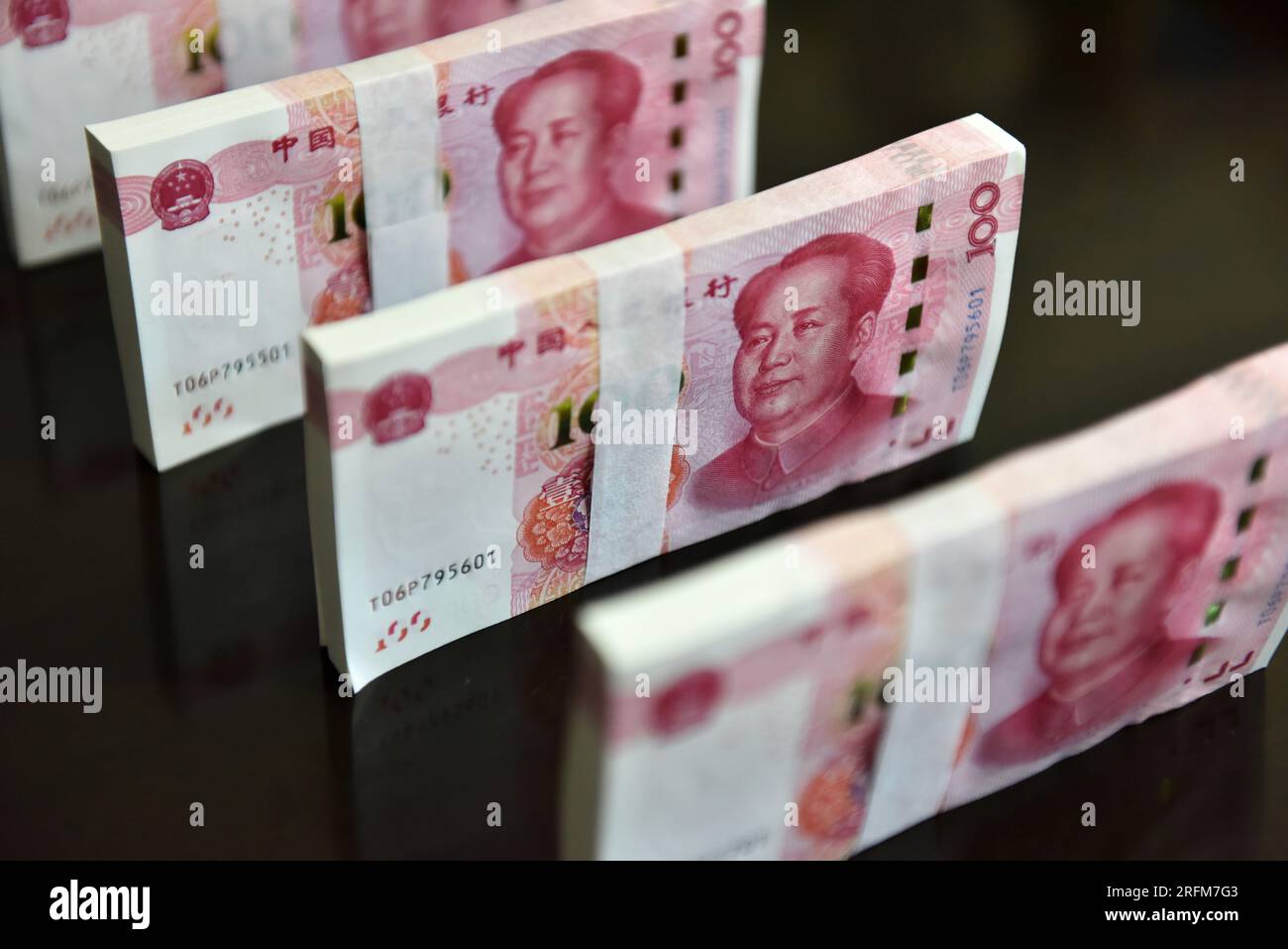 In this photo illustration, some 100 Chinese Yuan RMB (CNY) notes seen  displayed on a table Stock Photo - Alamy
