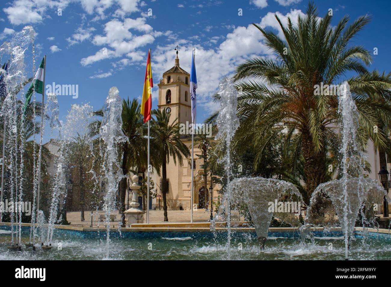 Albox, Almeria, Spain. The early 18c.parish church (Iglesia de Santa María)  seen through fountains playing in the Plaza de Pueblo. Stock Photo