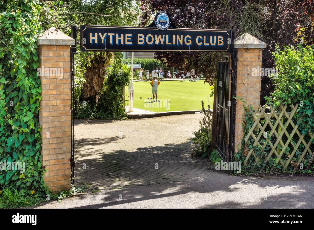 Looking through the gates of people playing bowls at Hythe Bowling Club Kent Stock Photo