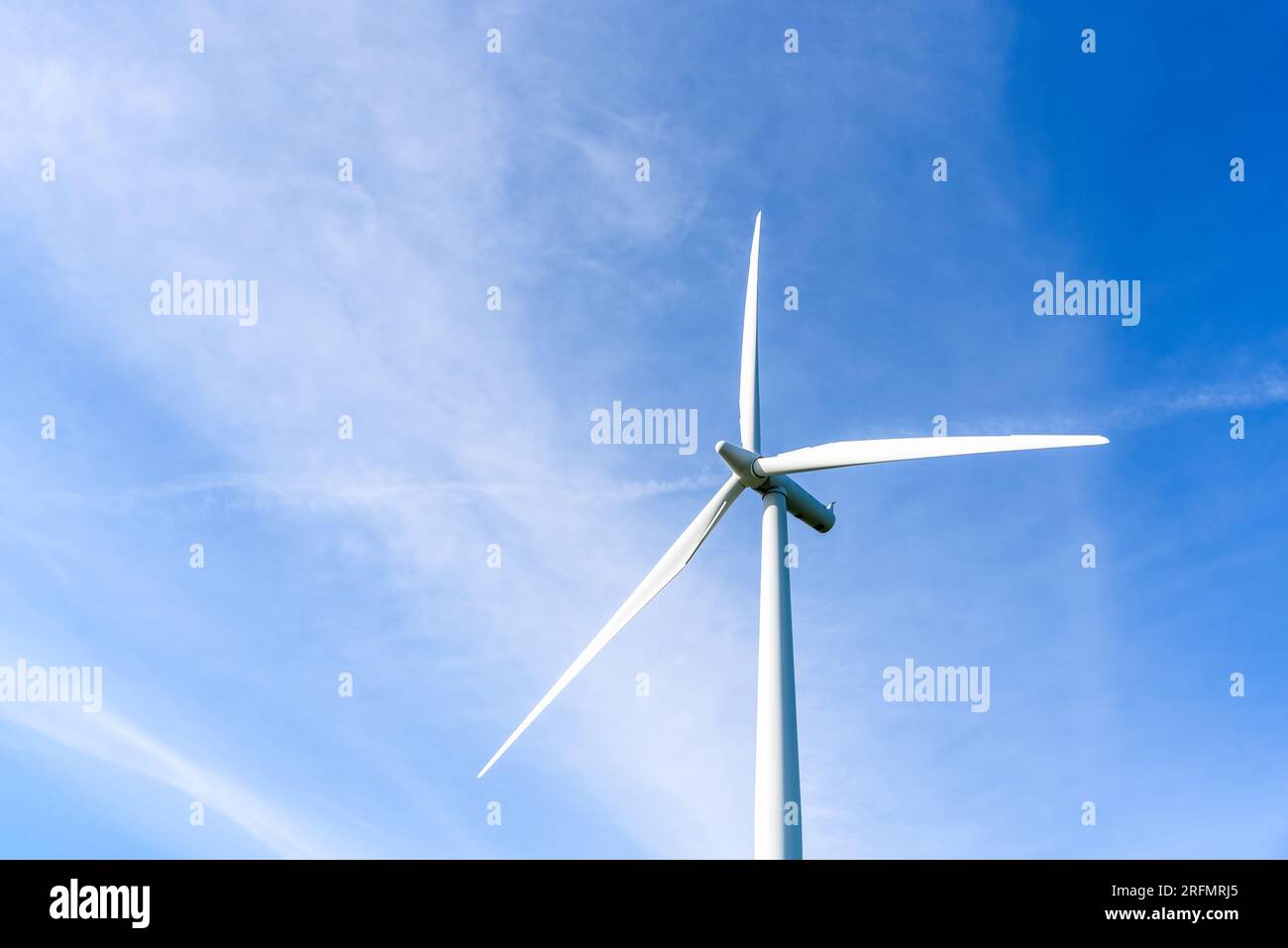 Detail of a wind turbine agaist blue sky with clouds on a sunny autumn day Stock Photo