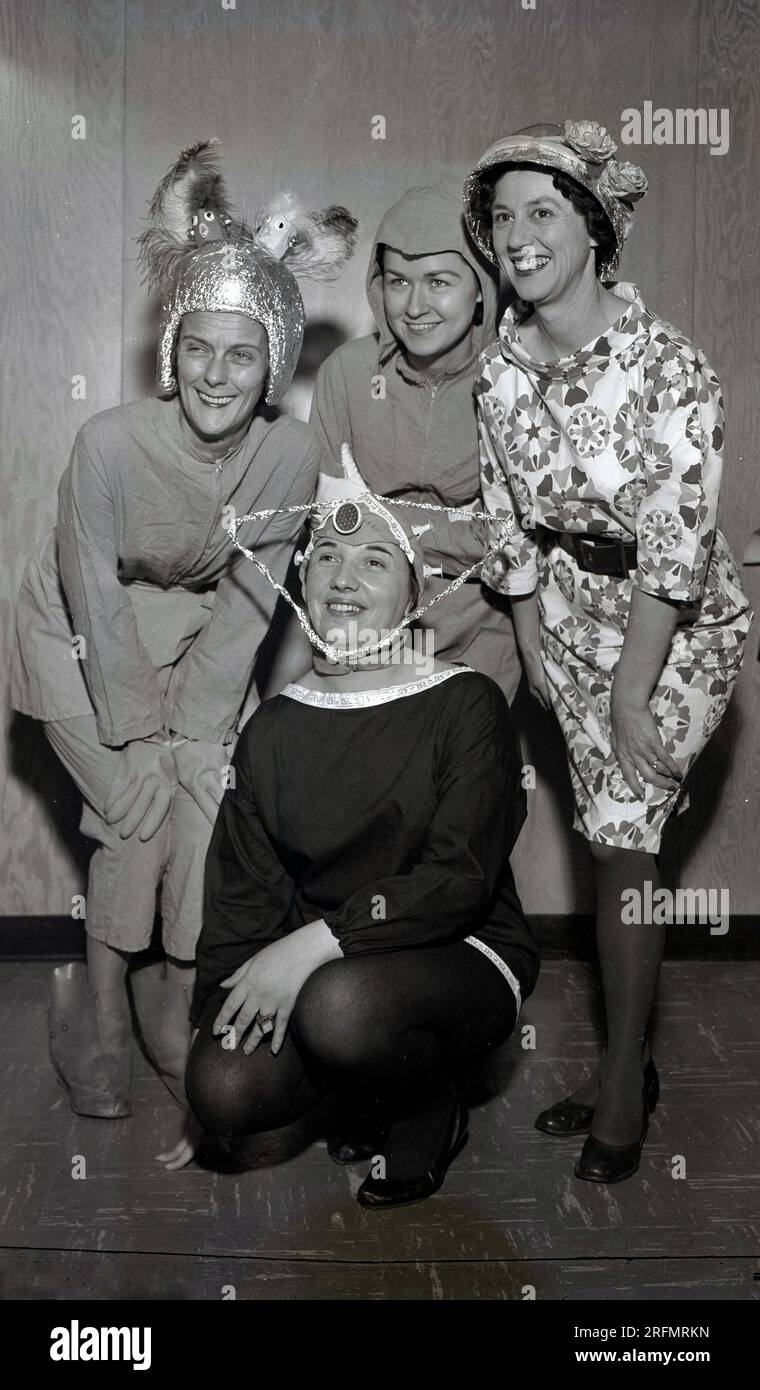 1954, historical, four ladies posing for a photo, three in costumes, wacky 'space' or Sci fi outfits, USA. The 1950s was a golden era for science fiction and over 200 films were produced during the decade. Stock Photo