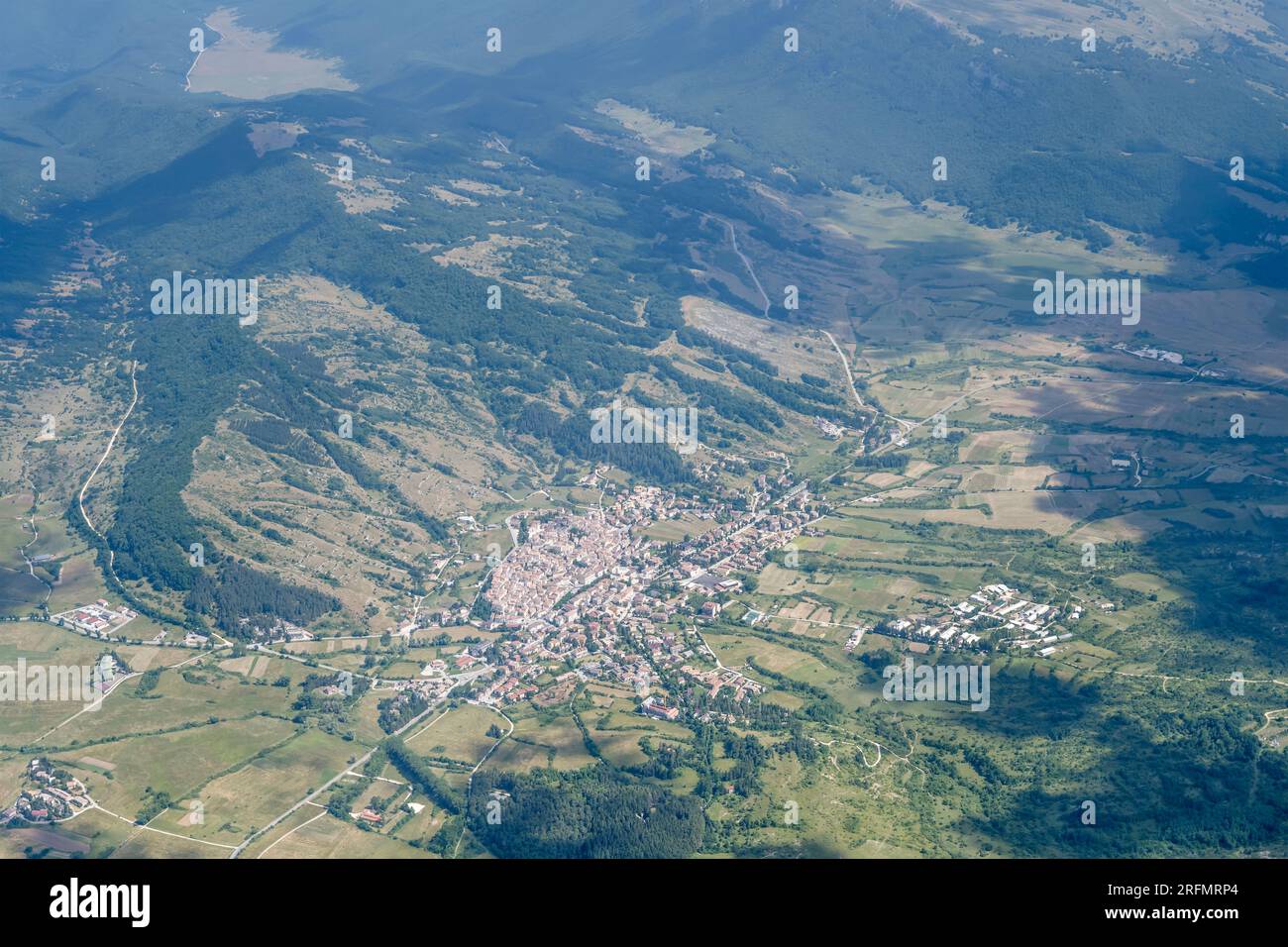 aerial landscape, from a glider plane, with  mountain village in green valley, shot from north-east in bright summer light at Rocca di Mezzo, Apennine Stock Photo